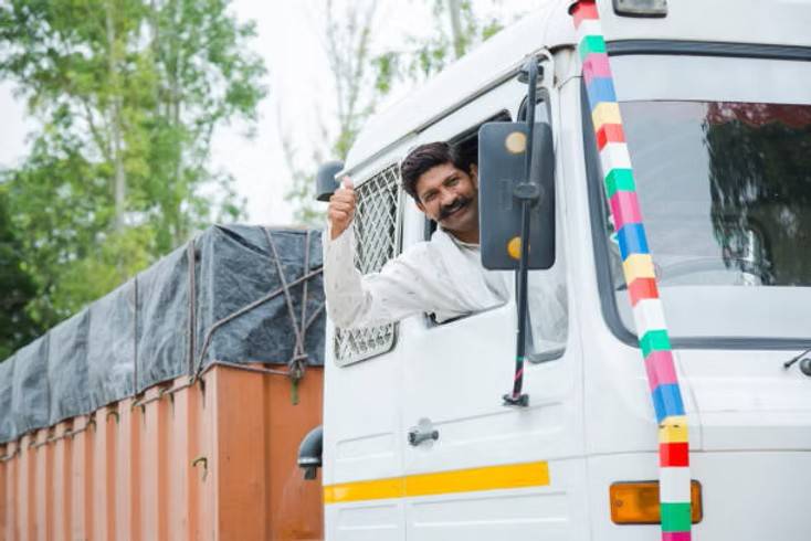 Experienced Indian truck driver giving thumbs up from vehicle cabin